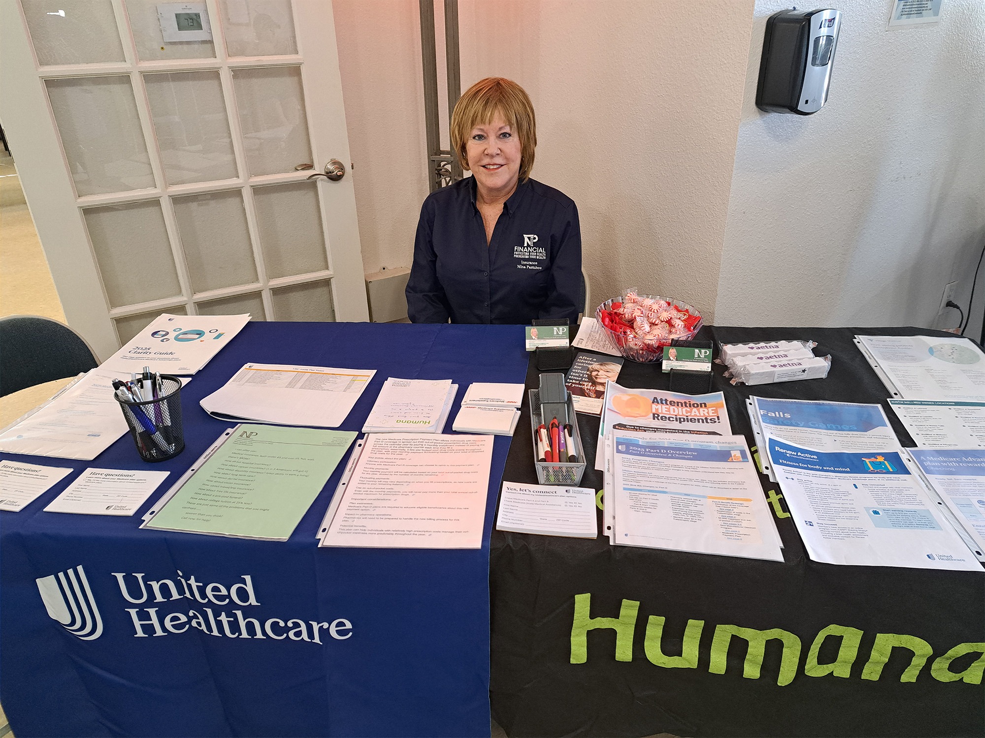 Woman sitting in front of a table full of documents smiling